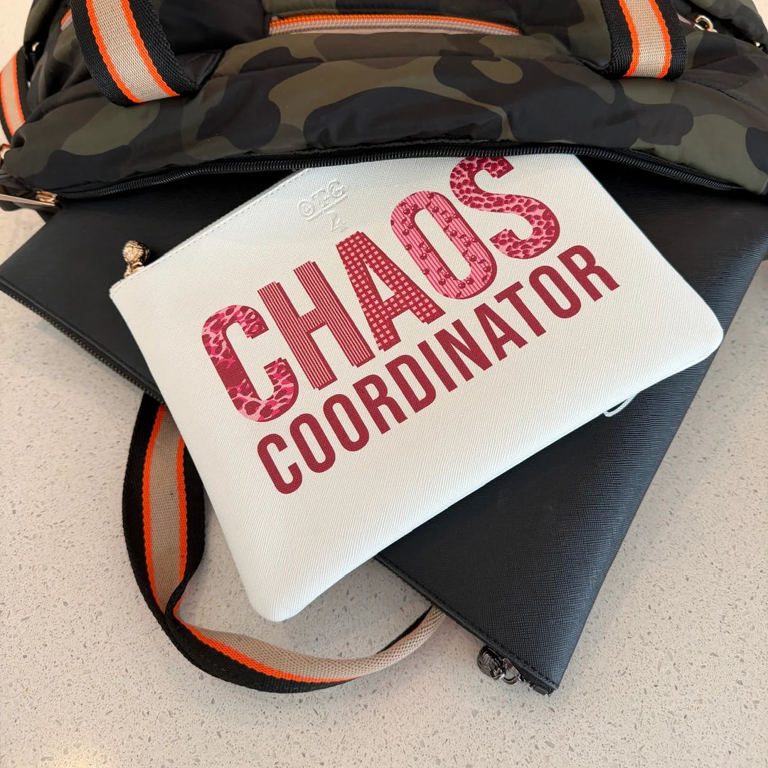 White #4 Chaos Coordinator pouch resting on a camo weekender bag